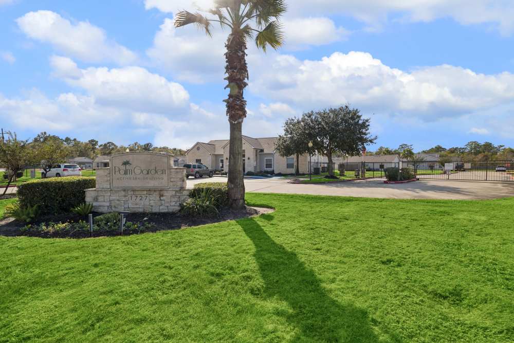 Front entrance sign of community  and green lawn at Palm Garden in Orange, Texas