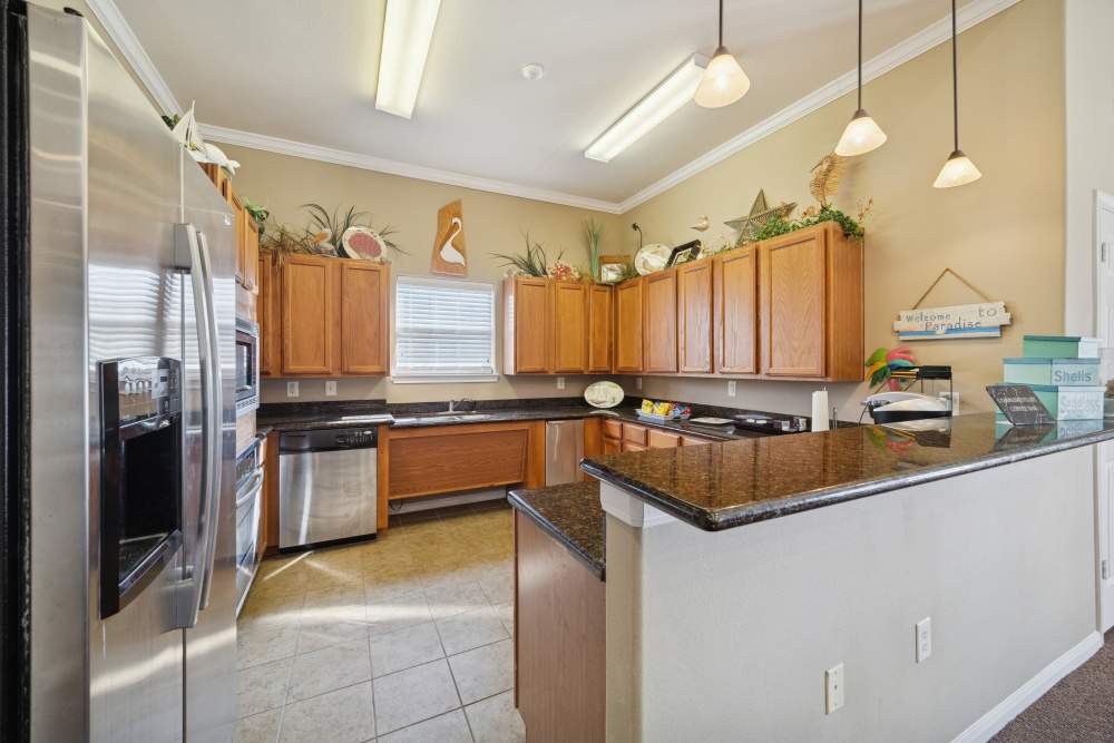 Kitchen with wooden cabinets, granite countertops, stainless steel appliances at Palm Garden in Orange, Texas