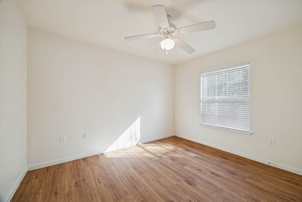 Unfurnished bedroom with window and ceiling fan at Palm Garden in Orange, Texas