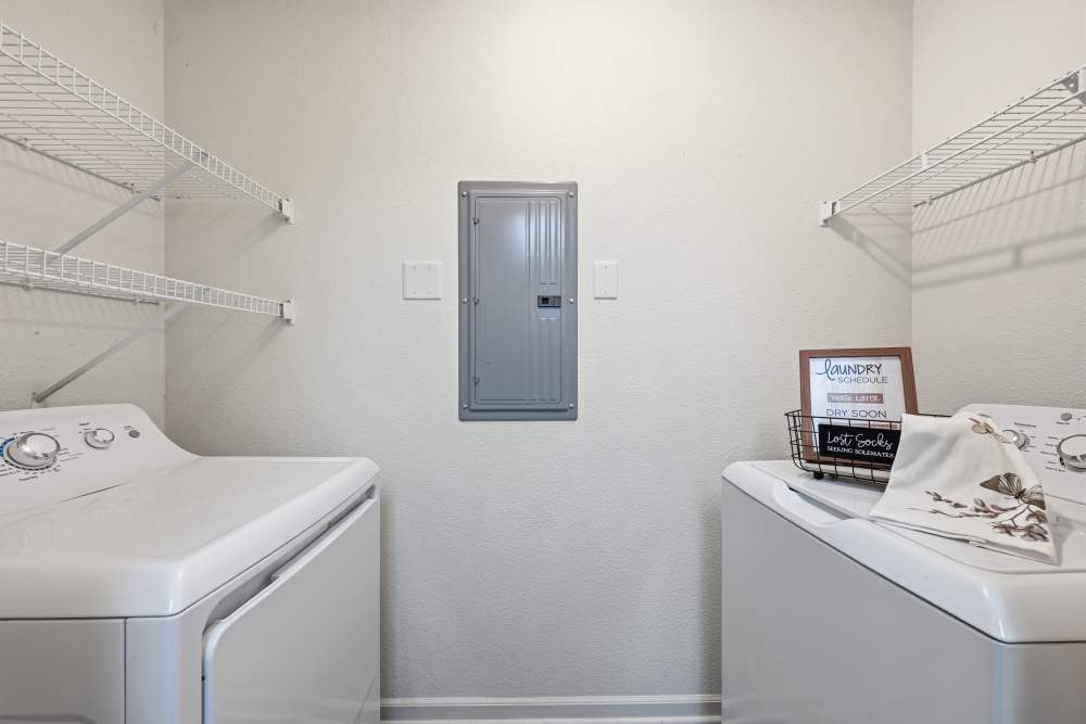 Bright laundry room with modern appliances and organized shelving at Riverside Park in Early, Texas