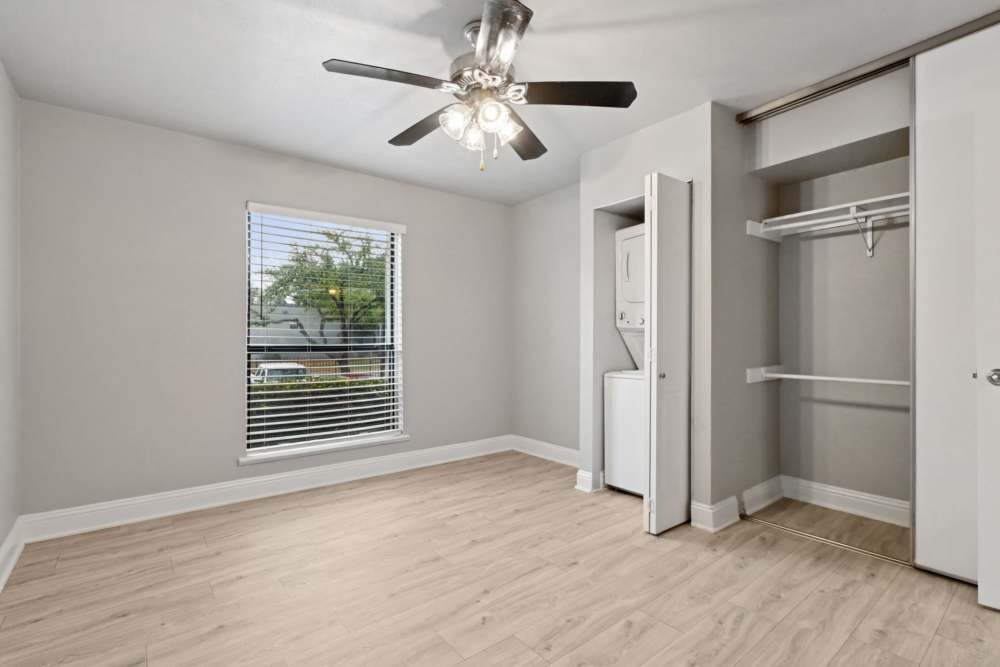 Unfurnished bedroom with attached closet and in-unit washer and dryer at Avondale Parc at Bellmar in Dallas, Texas