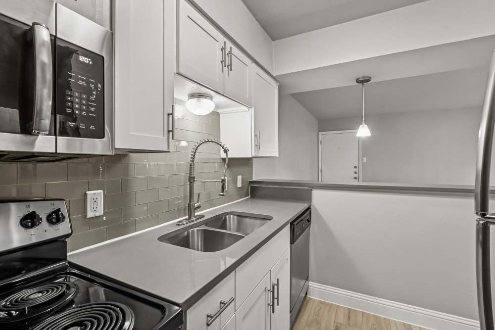 Fully-equipped kitchen with white cabinetry at Aberdeen at Bellmar in Dallas, Texas