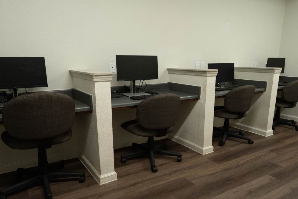 Modern workspace with multiple computer stations and comfortable chairs at Savannah Terrace in Mustang, Oklahoma