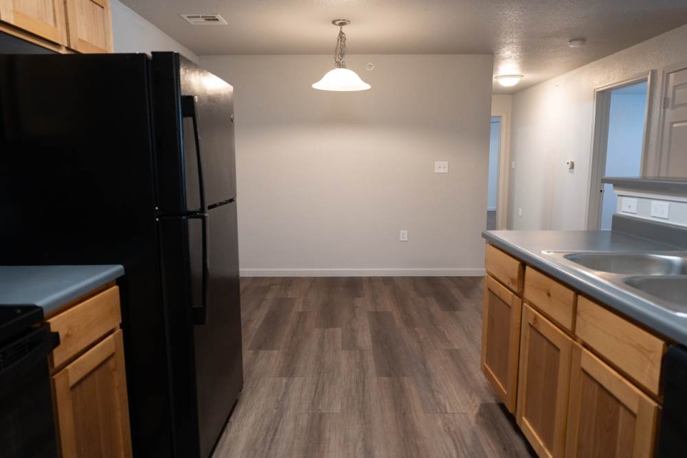 Modern kitchen with sleek black appliances and wooden cabinetry at Savannah Terrace in Mustang, Oklahoma