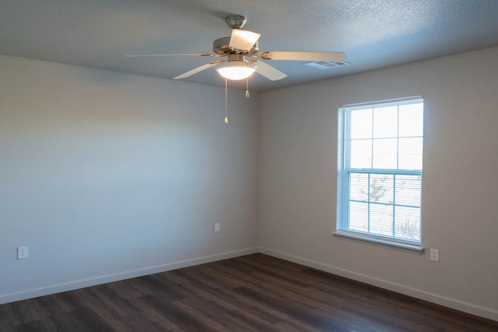Bright room with ceiling fan and large window at Savannah Terrace in Mustang, Oklahoma