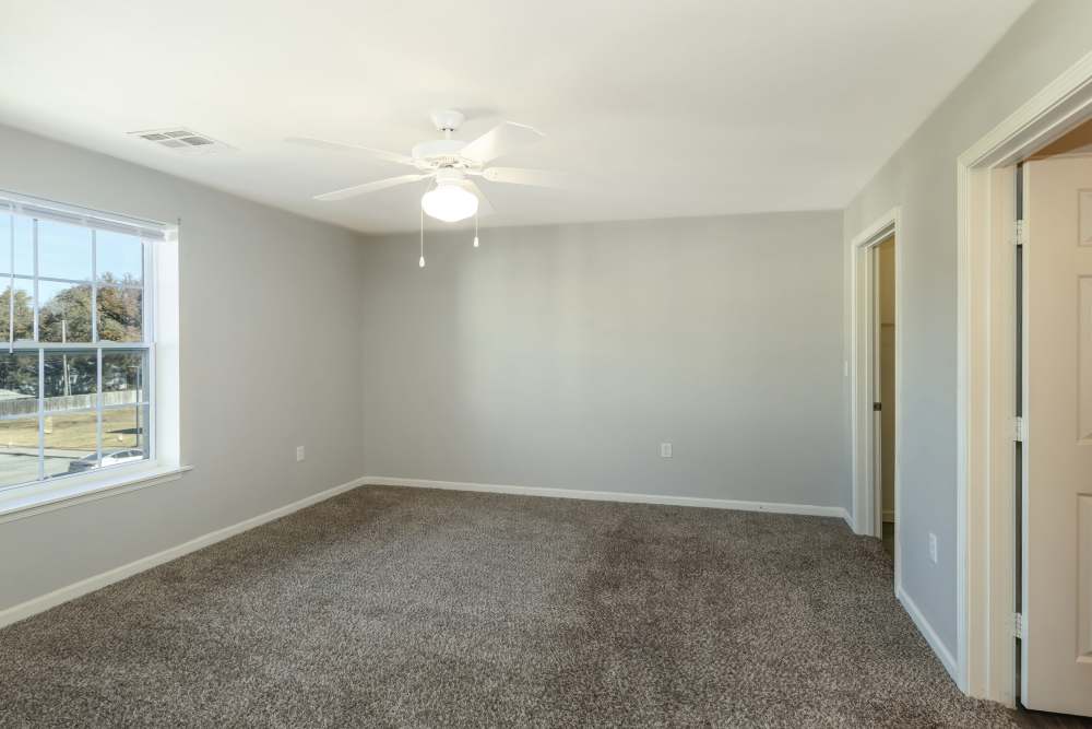 Well-lit apartment bedroom with carpet flooring at Sunnydale Pointe in Wichita, Kansas