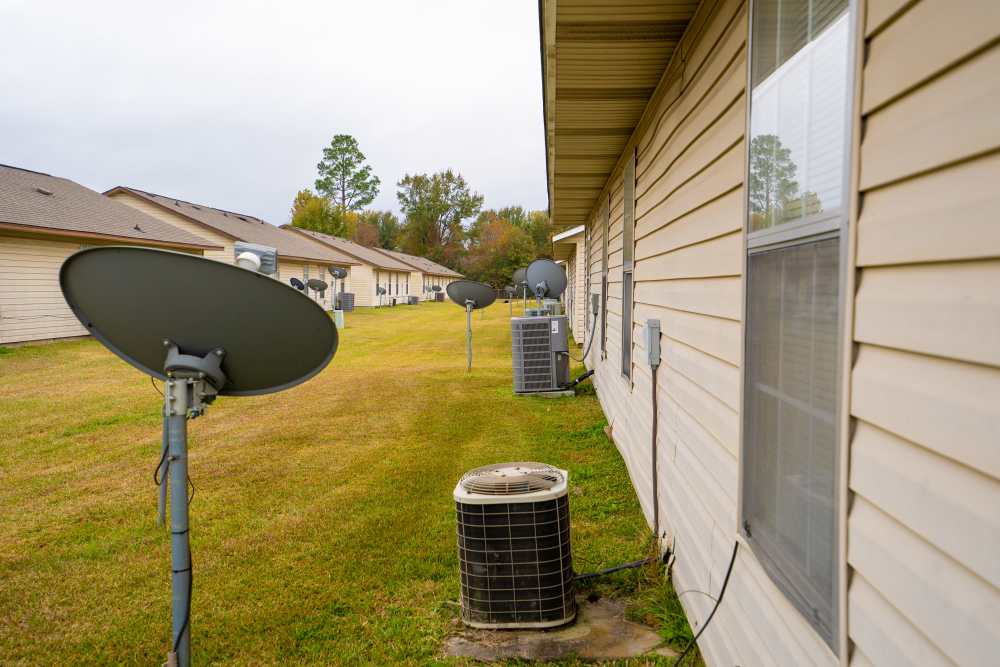 Lush green community with satellite dish and central air conditioning installed at Willowbrook II in Lafayette, Louisiana