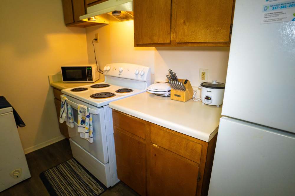 White appliances and wooden cabinets of apartment at Willowbrook II in Lafayette, Louisiana