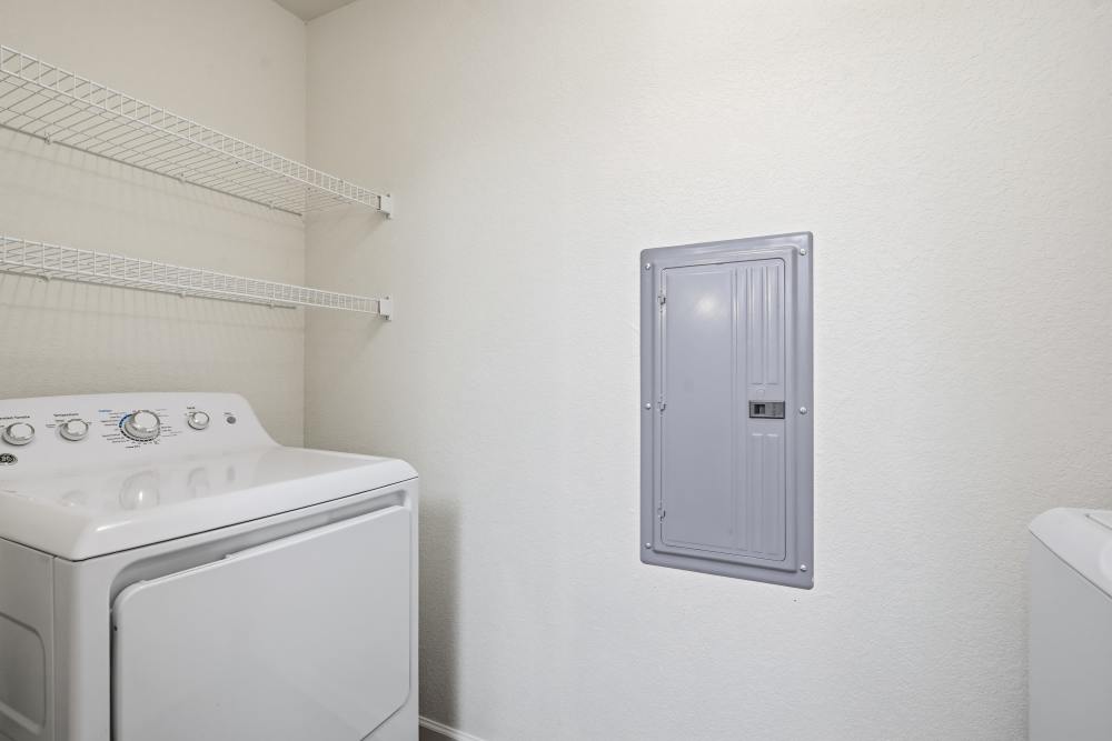 Bright laundry room with modern washer and wire shelving at Wood Falls in Lebanon, Tennessee