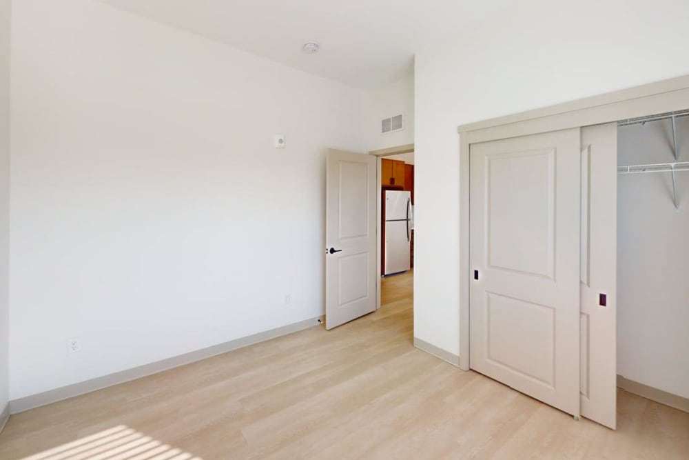Bedroom with sliding closet doors and light flooring at Terra Station, Hudsonville, Michigan