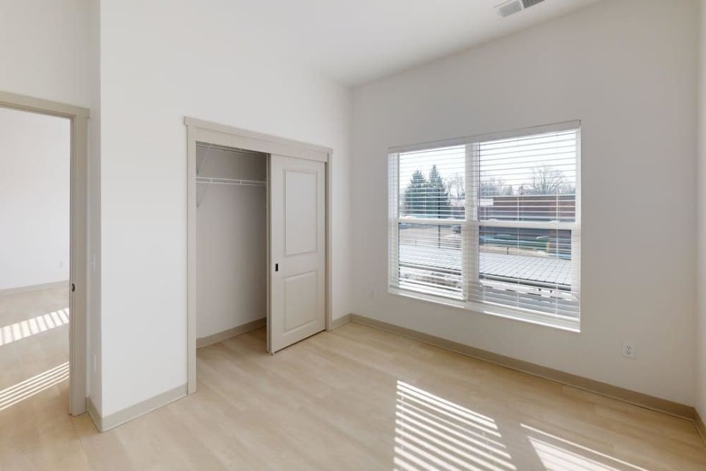 Sunlit bedroom with large window and open closet space at Terra Station, Hudsonville, Michigan