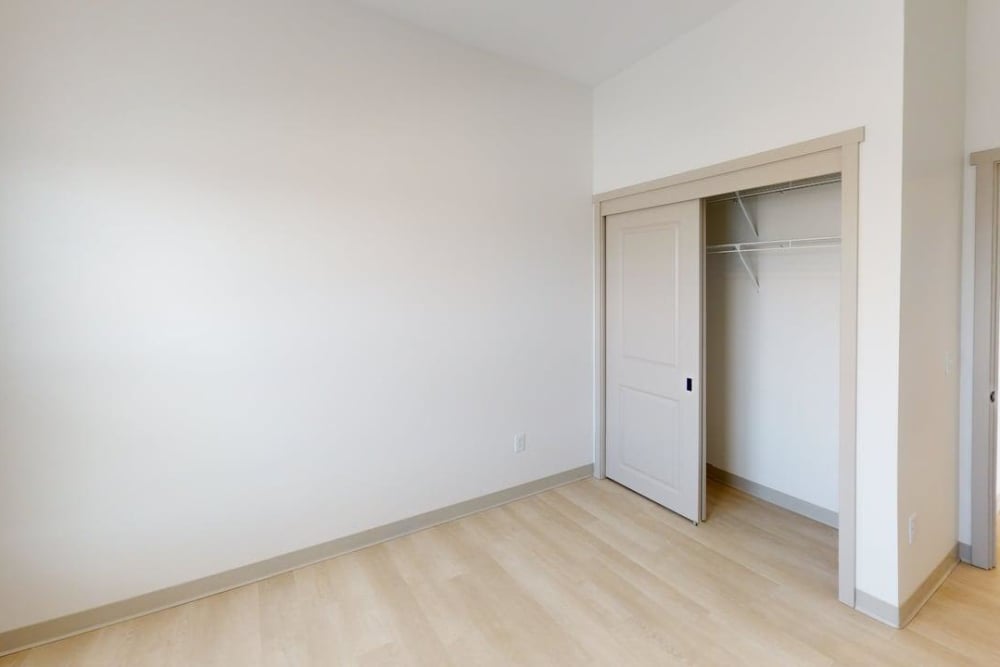 Bedroom with sliding closet and neutral finishes at Terra Station, Hudsonville, Michigan