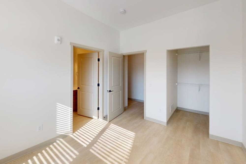 Bright bedroom with open closet and light wood flooring at Terra Station, Hudsonville, Michigan