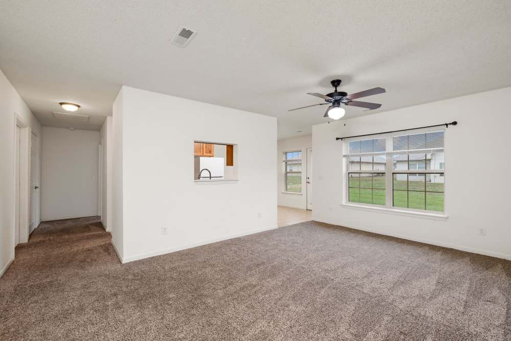 Unfurnished living room and access to kitchen and dining area at Oaklawn Estates in Rogersville, Missouri 