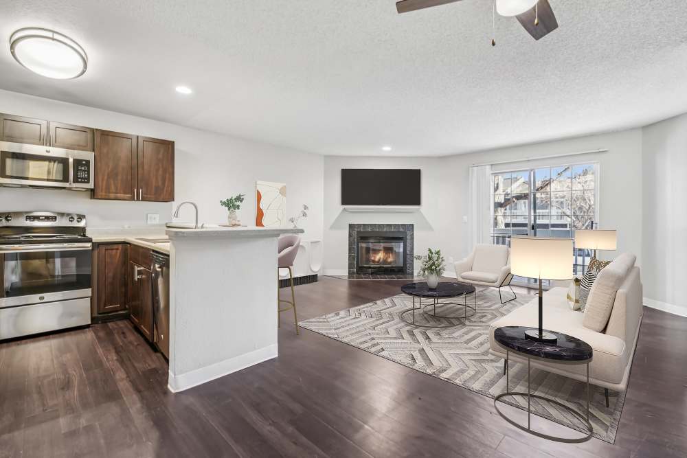 Kitchen with brown cabinets and spacious living room at Bluesky Landing Apartments in Lakewood, Colorado