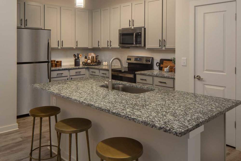 Kitchen with a breakfast counter at Arden at South Point Apartment Homes in McDonough, Georgia