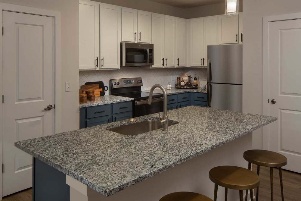 Modern kitchen with wooden cabinets at Arden at South Point Apartment Homes in McDonough, Georgia