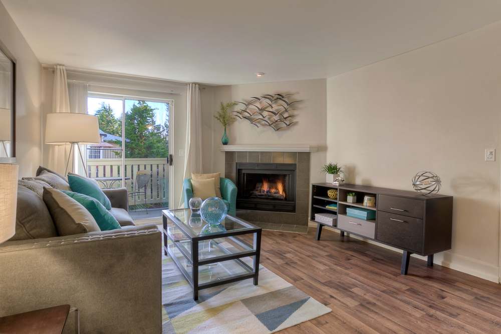 Living room with attached patio  at Newport Crossing Apartments in Newcastle, Washington