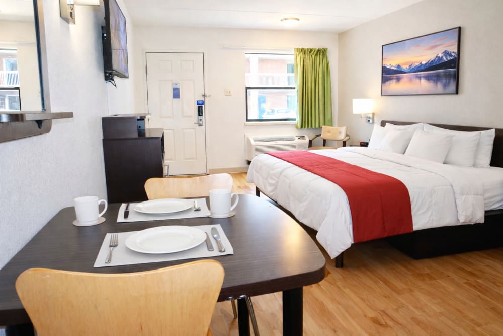 Studio apartment with cozy bed and dining area at Trailhead Flats in Colorado Springs, Colorado