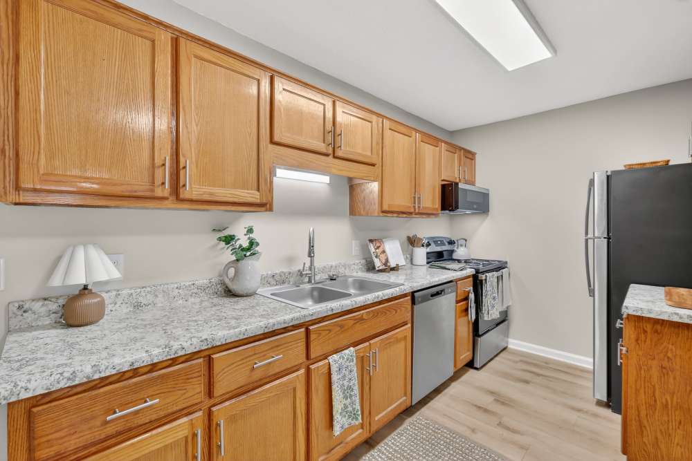 Open-concept living room and dining area with bright interiors and spacious kitchen at Saddlebrook Apartments.