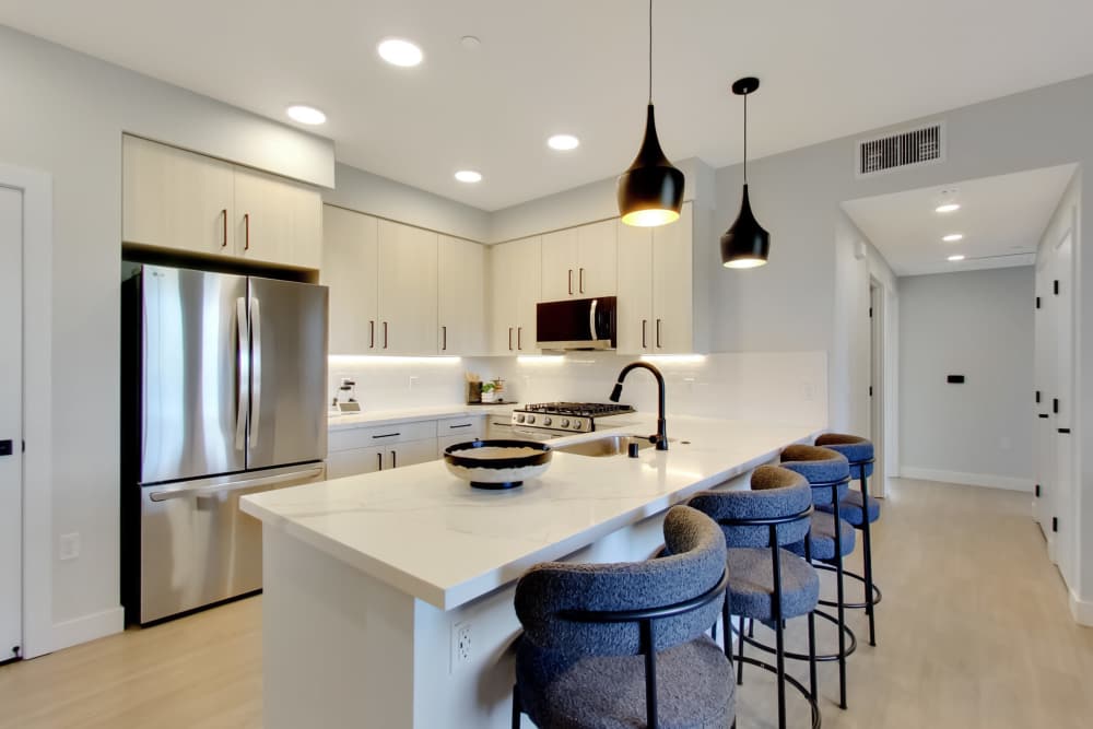Modern kitchen with granite countertops, stainless steel appliances, and stylish pendant lights over a breakfast bar at Domaine at Napa Junction in American Canyon, California