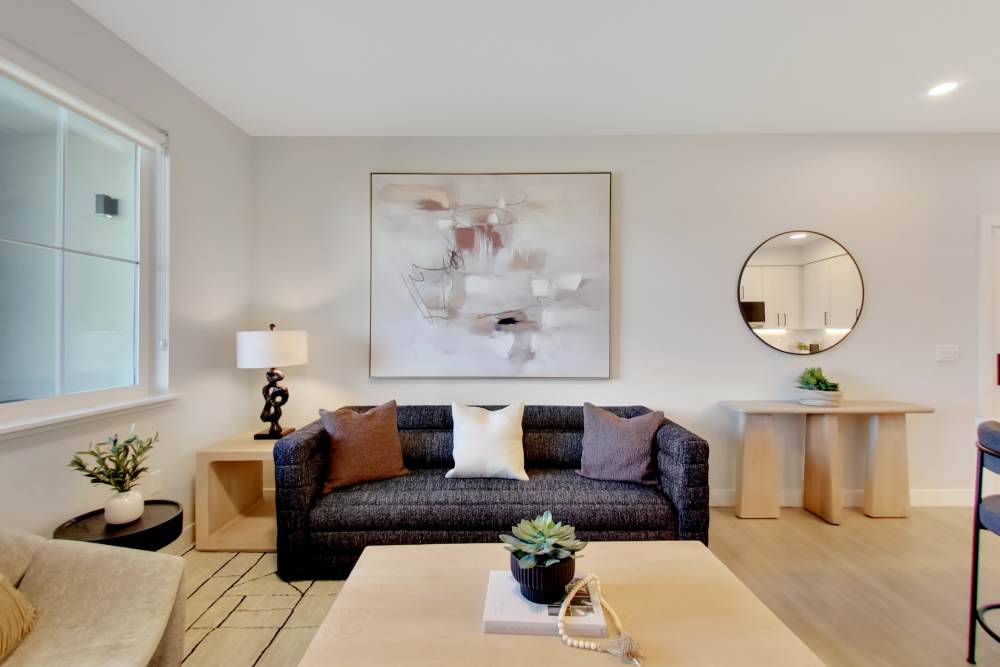Modern living room with wood-style flooring, stylish couch, and decorative art on the wall at Domaine at Napa Junction in American Canyon, California