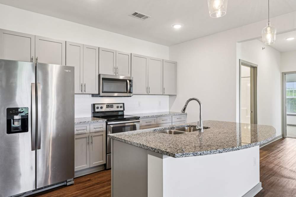Kitchen with granite counters, stainless appliances, and view toward living area at The Drake in Bowling Green, Kentucky  