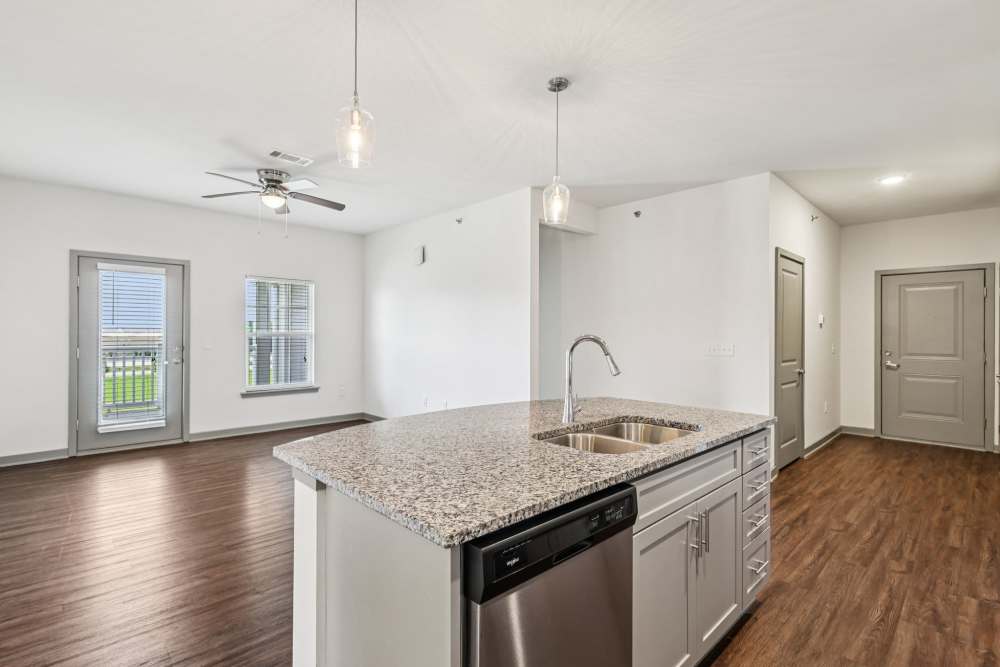Kitchen with granite counters, stainless appliances, and view toward living area at The Drake in Bowling Green, Kentucky  