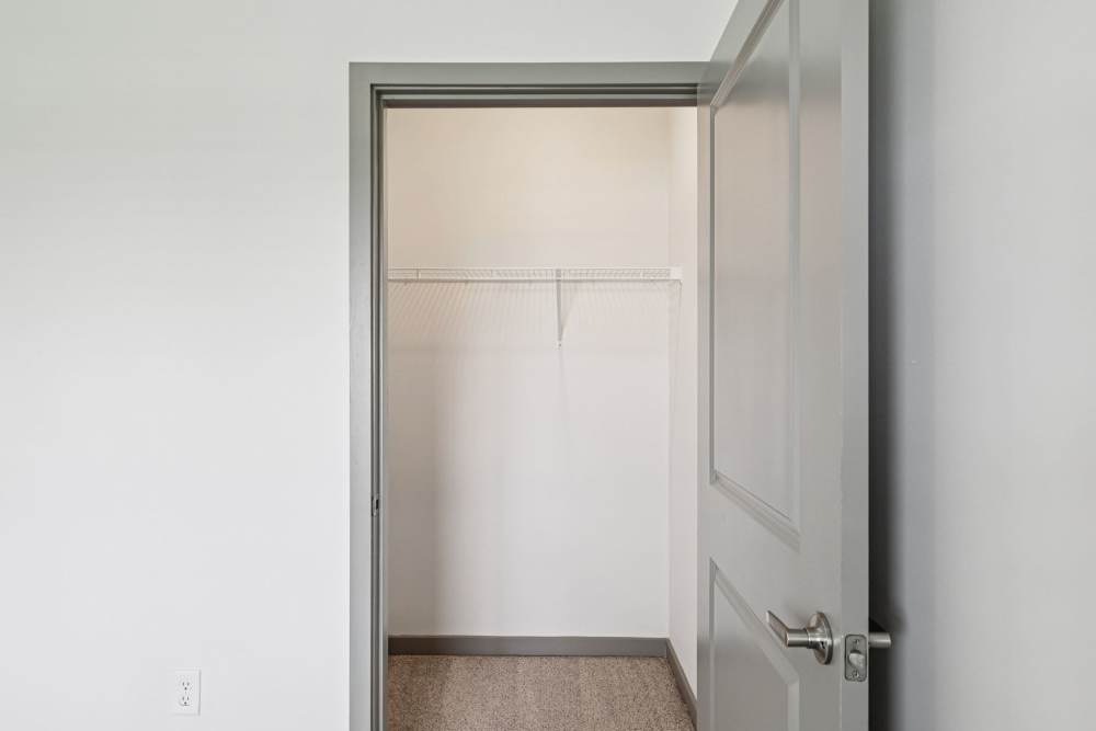 Open closet with white wire shelf above carpeted floor, viewed through doorway at The Drake in Bowling Green, Kentucky  