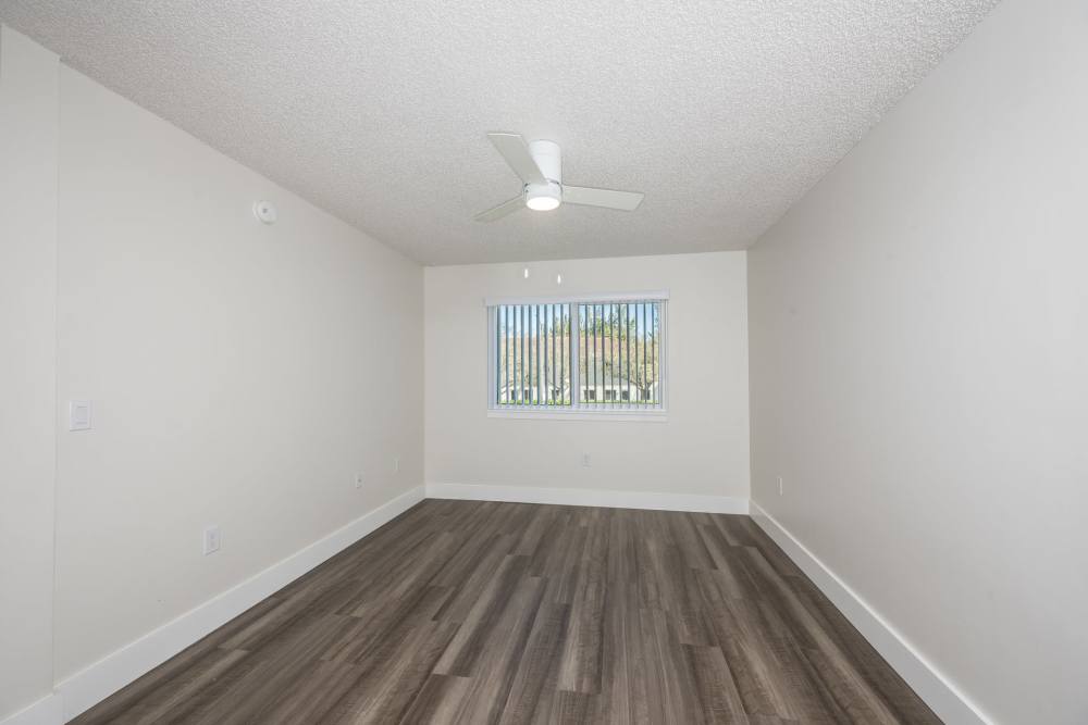 Apartment bedroom with vinyl plank flooring and ceiling fan at Ernie Martin Villas in Miami, Florida