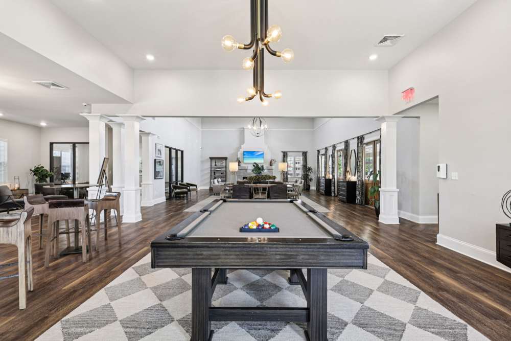 Large gathering room with pool table, seating areas, and wide walkway between spaces at The Drake in Bowling Green, Kentucky