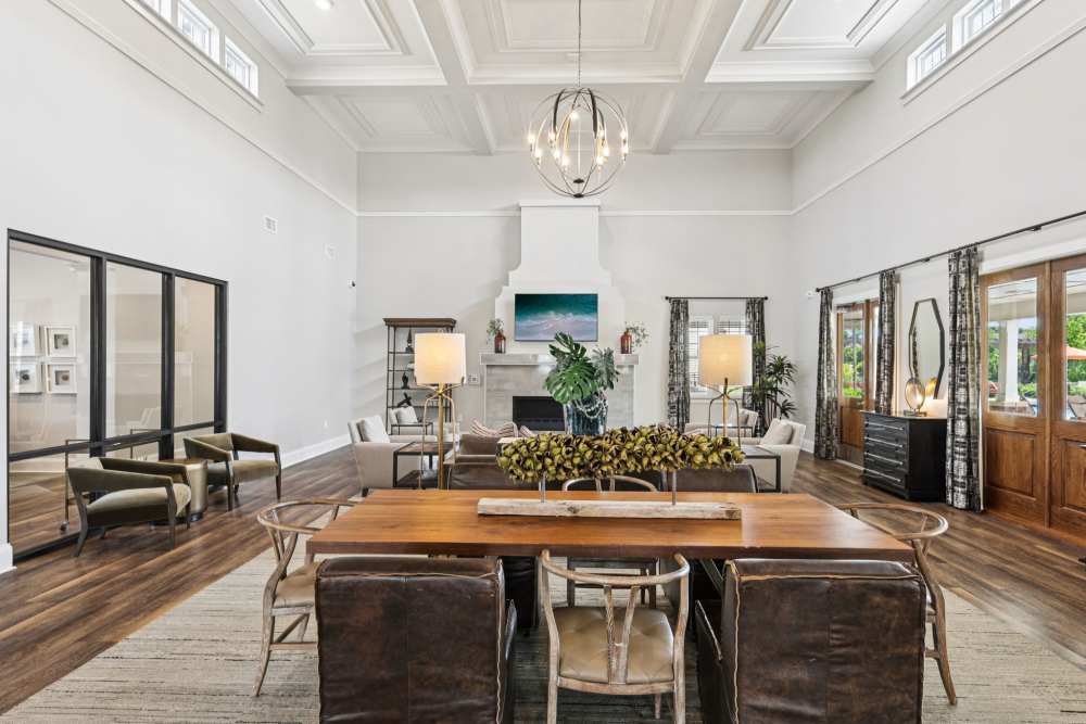 Large lounge with dining table, sofas, and high ceiling with hanging light fixture at The Drake in Bowling Green, Kentucky