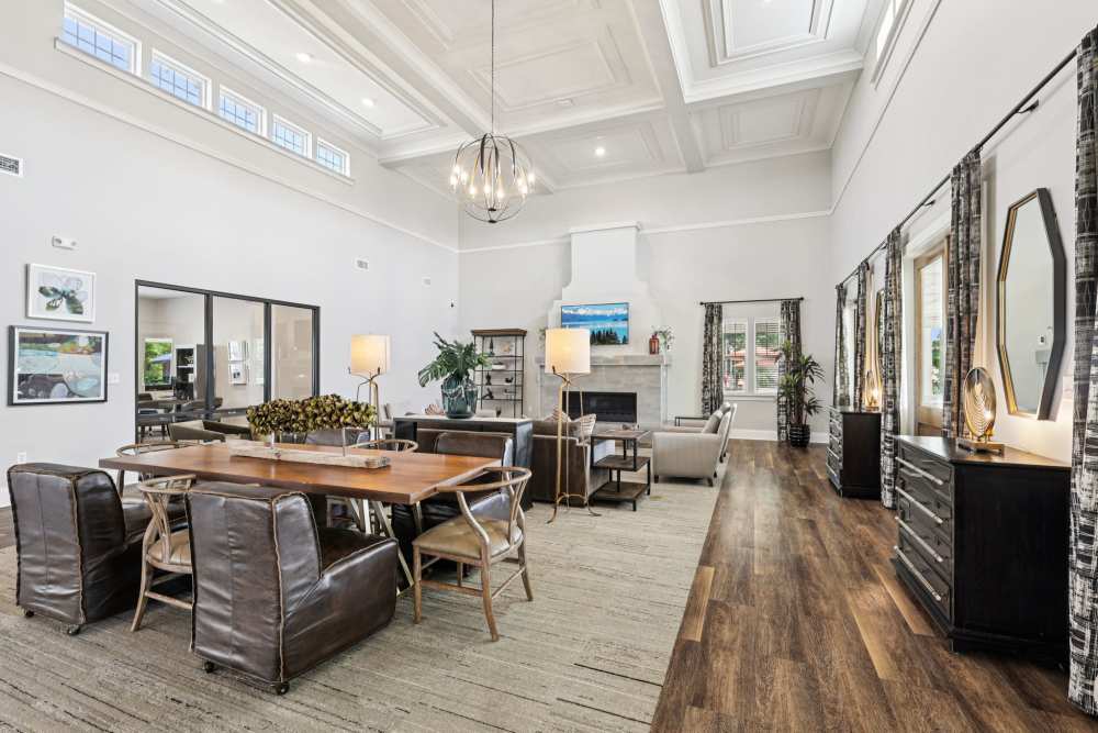 Lounge with long dining table, sofas, and tall windows with patterned curtains at The Drake in Bowling Green, Kentucky