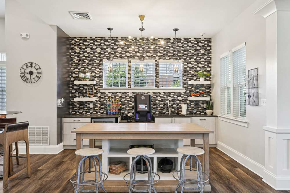 Coffee station area with mosaic tile wall, windows, counter space, and barstools at The Drake in Bowling Green, Kentucky