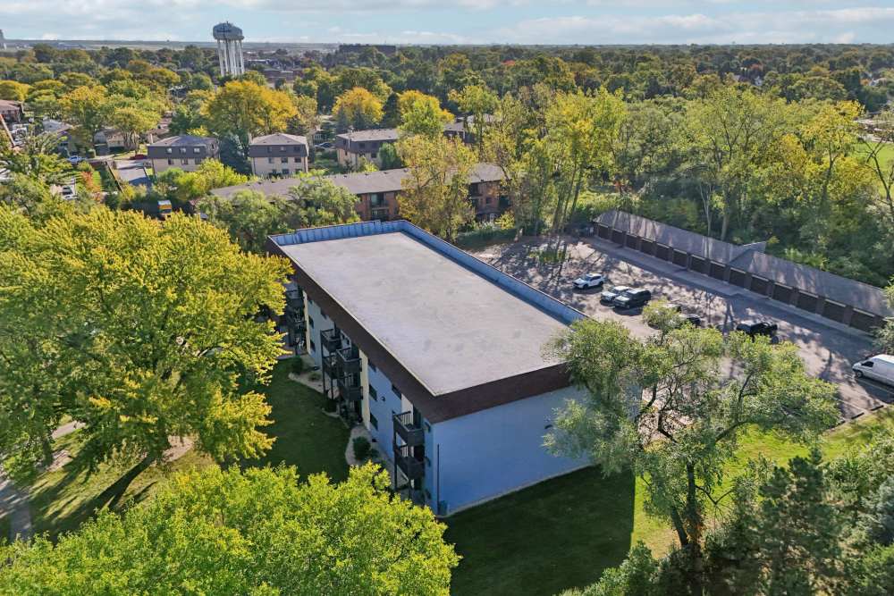 Aerial view of apartment building surrounded by trees at Regents Park Apartments in Bensenville, Illinois
