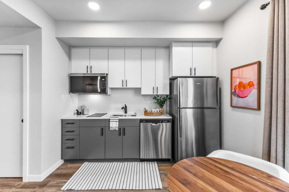 Contemporary kitchenette with two-tone cabinets and fridge at Cartwright Apartments in Salem, Oregon