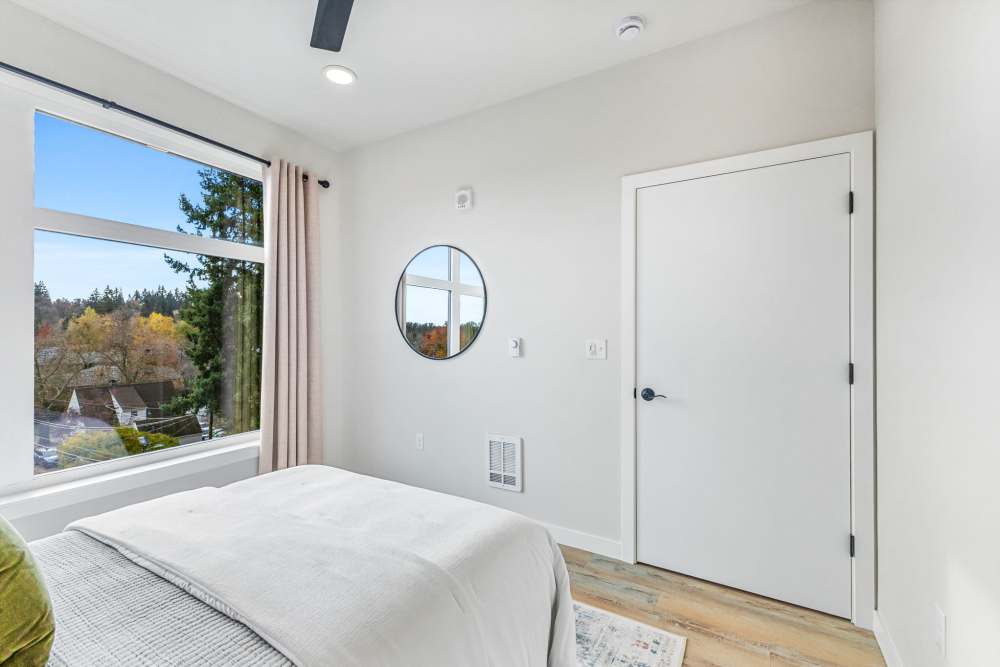 Bedroom with large window, light walls, and simple decor at Cartwright Apartments in Salem, Oregon
