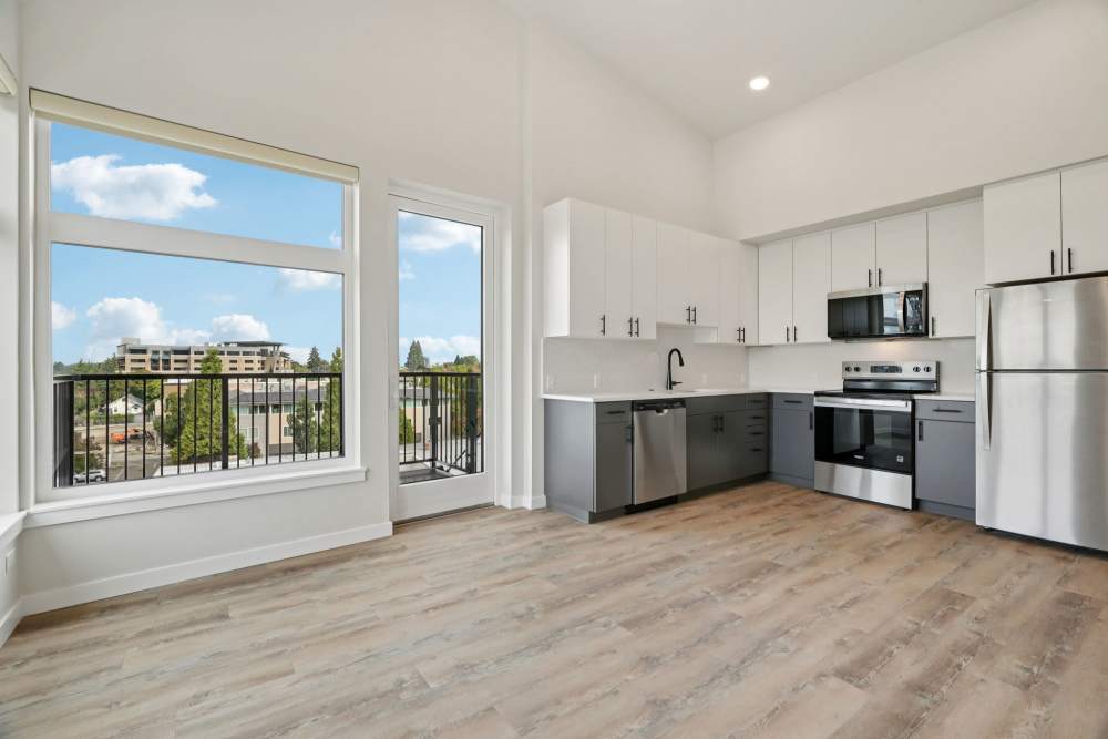 Kitchen and living space with tall ceilings and large windows at Cartwright Apartments in Salem, Oregon