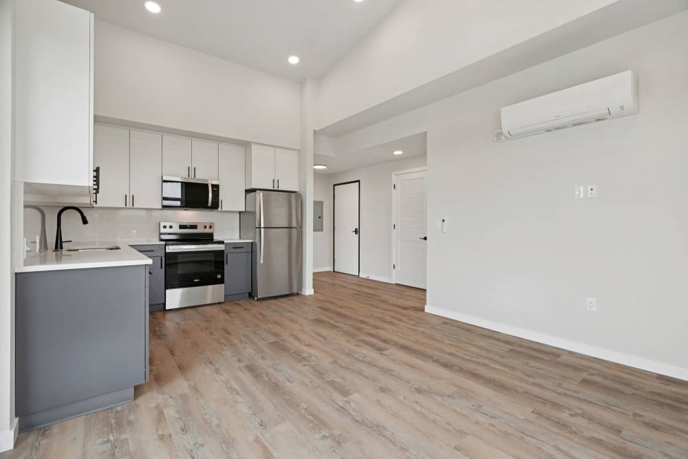 Open kitchen and living room with stainless appliances and wood floors at Cartwright Apartments in Salem, Oregon