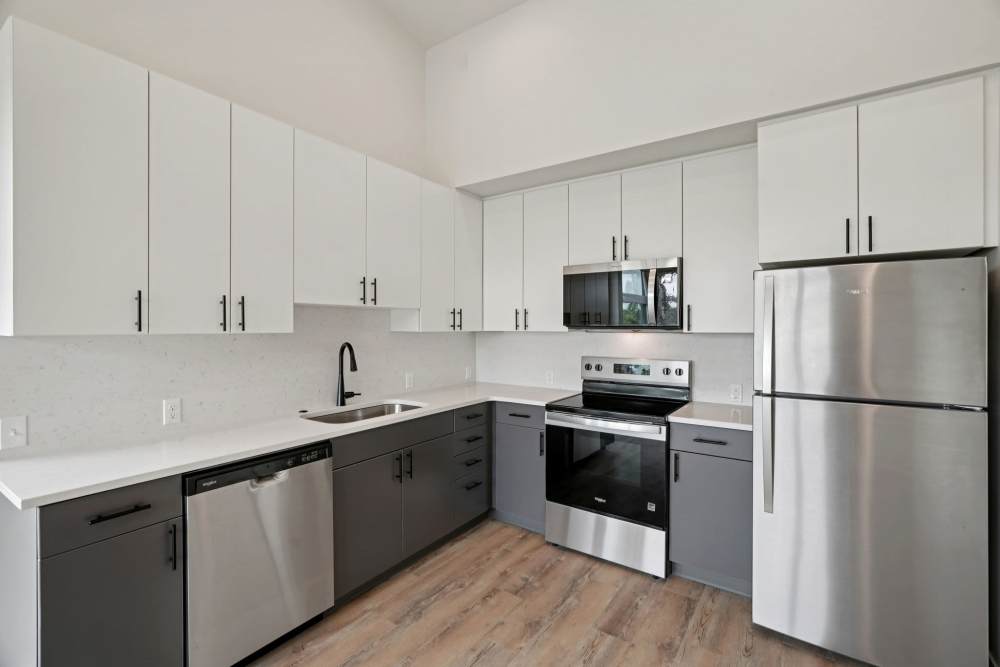 Kitchen with white cabinets, stainless appliances, and wood flooring at Cartwright Apartments in Salem, Oregon