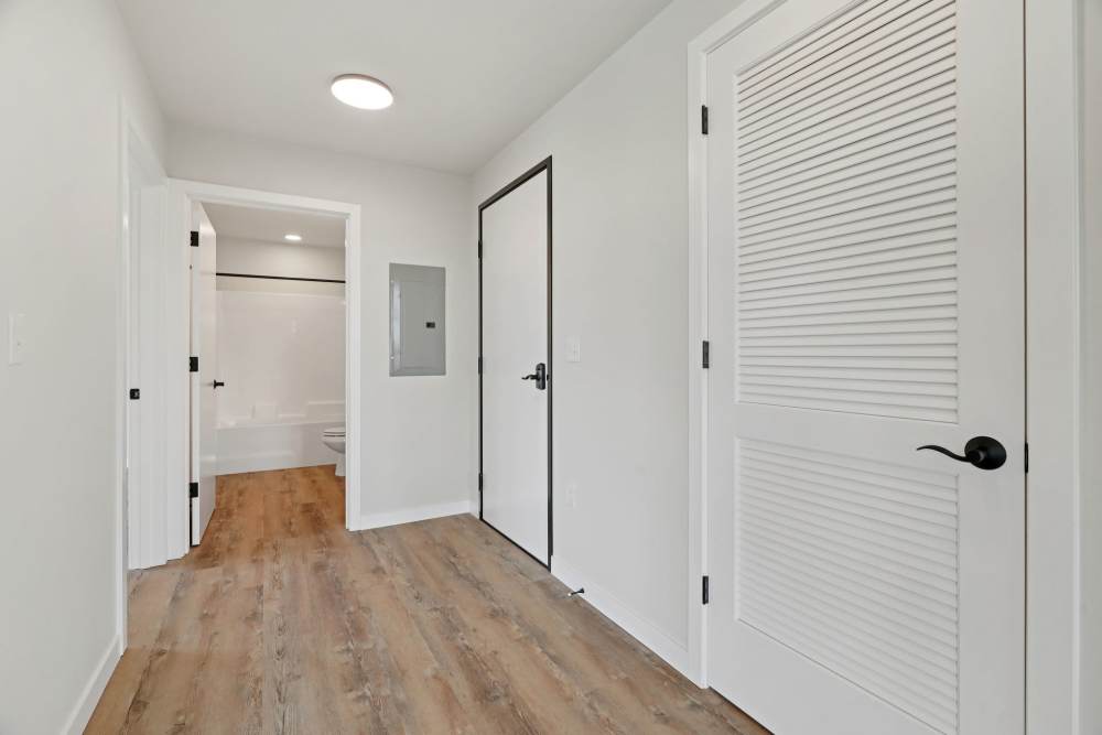 Hallway with wood floors, utility panel, and bathroom entry at Cartwright Apartments in Salem, Oregon