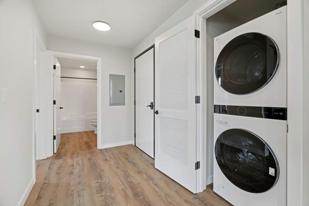 Hallway with stacked washer and dryer leading to bathroom at Cartwright Apartments in Salem, Oregon