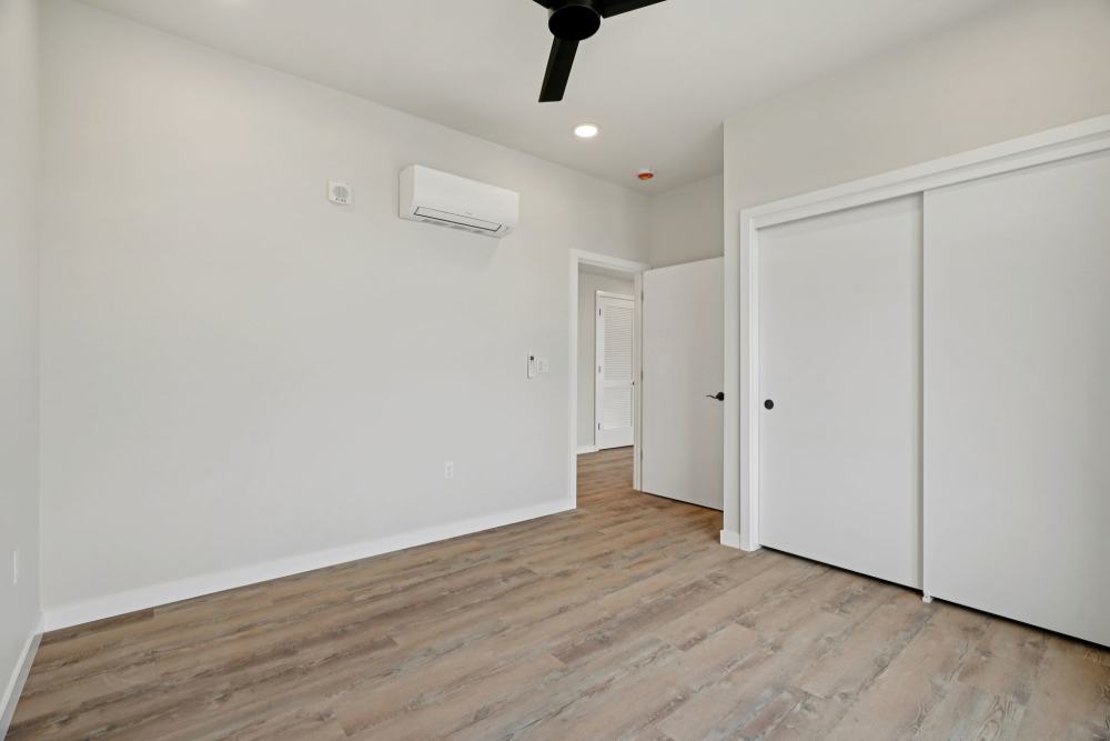 Bedroom with large windows, balcony door, and wood flooring at Cartwright Apartments in Salem, Oregon