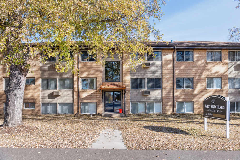 Exterior view of the apartment with community sign board at West End Trails in Golden Valley, Minnesota