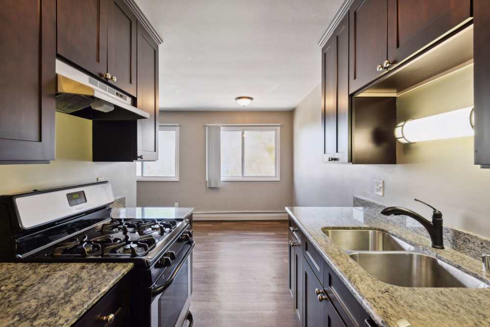 Kitchen with wooden cabinets and double sink at West End Trails in Golden Valley, Minnesota