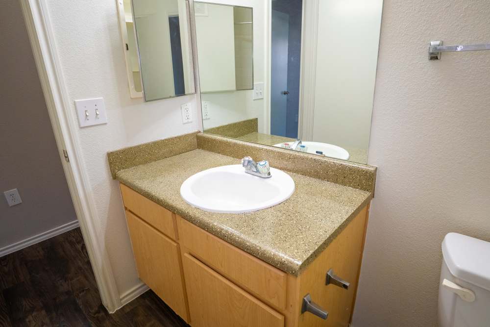 Bathroom with vanity mirror at Timber Village in Marshall, Texas