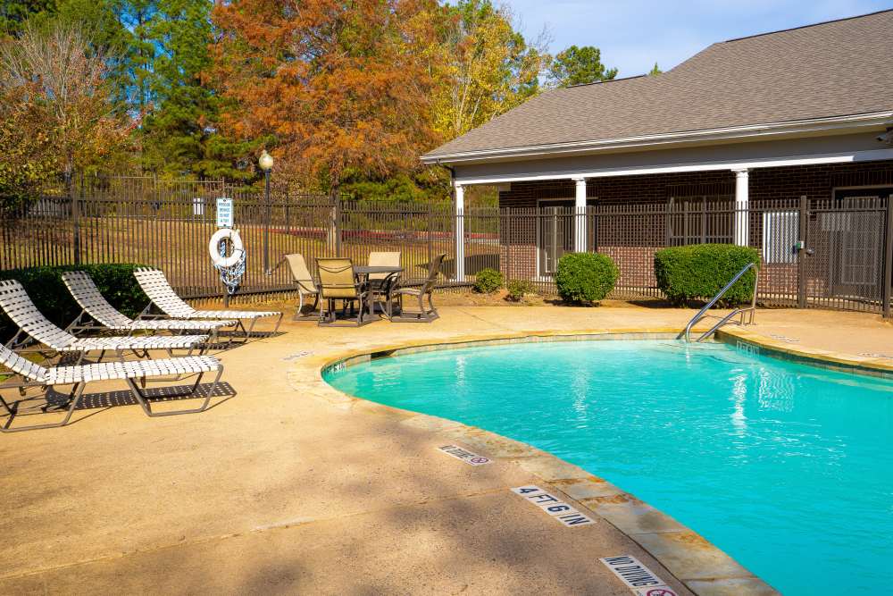 Pool with lounge chairs at Timber Village in Marshall, Texas