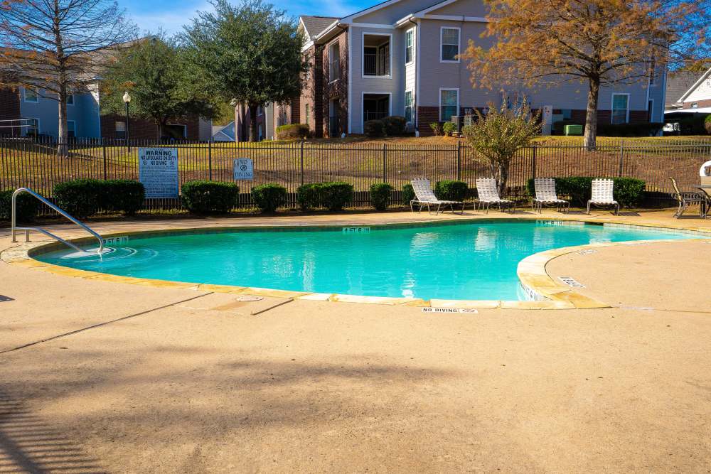 Pool with view to community building at Timber Village in Marshall, Texas