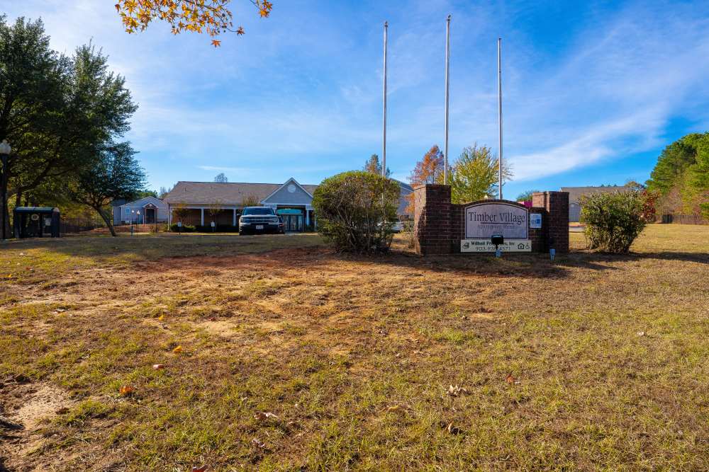Community signage with building at Timber Village in Marshall, Texas  