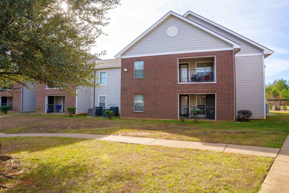 Building exterior view with patio at Timber Village in Marshall, Texas
